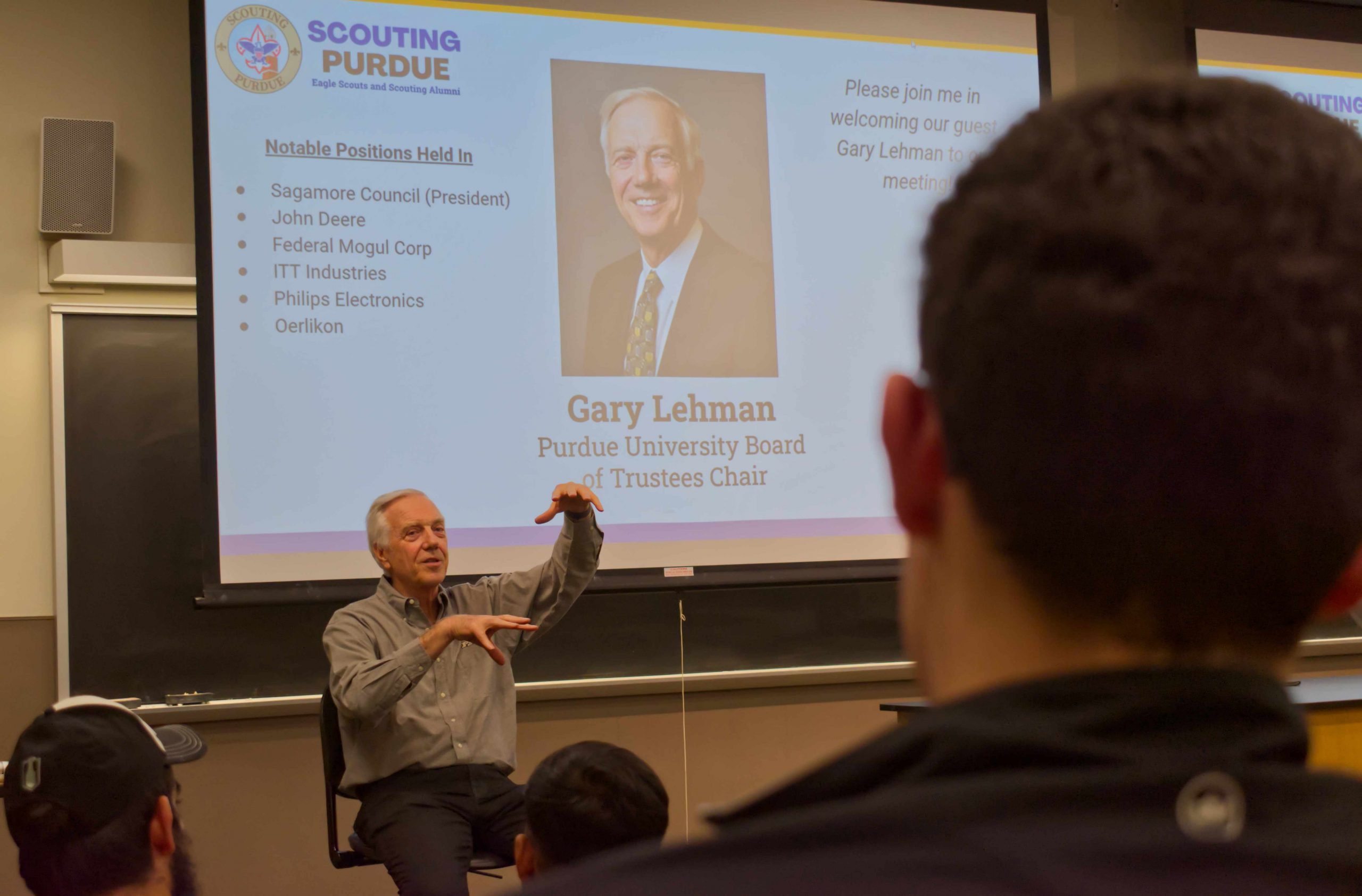 Guest speaker gestures to crowd