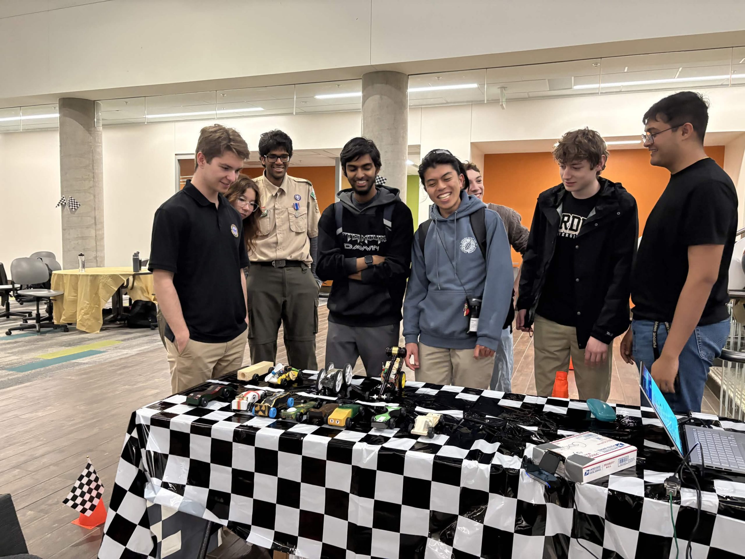 Group laughing and looking at Pinewood Derby cars